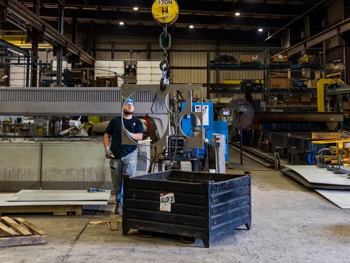Industrial worker operating lifting equipment inside a factory